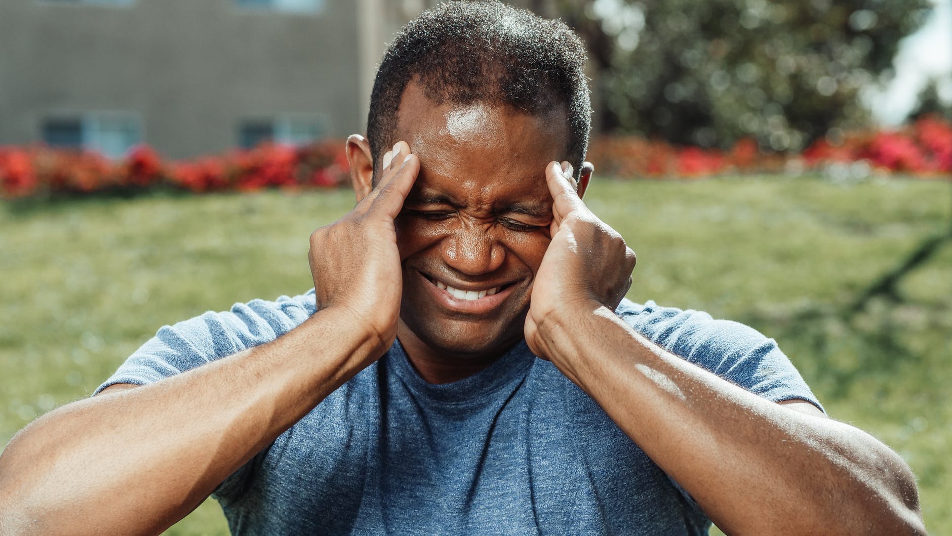 man in gray crew neck t shirt covering his face with his hand