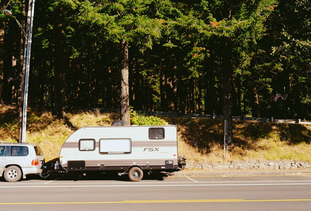 a truck towing a camper on the side of the road